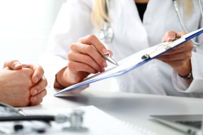 Doctor showing clipboard to patient
